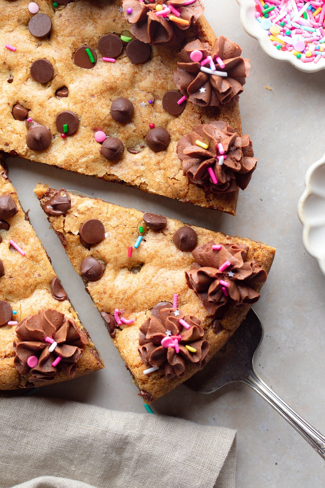 Near a slice of a vegan cookie cake rising from the whole cake.