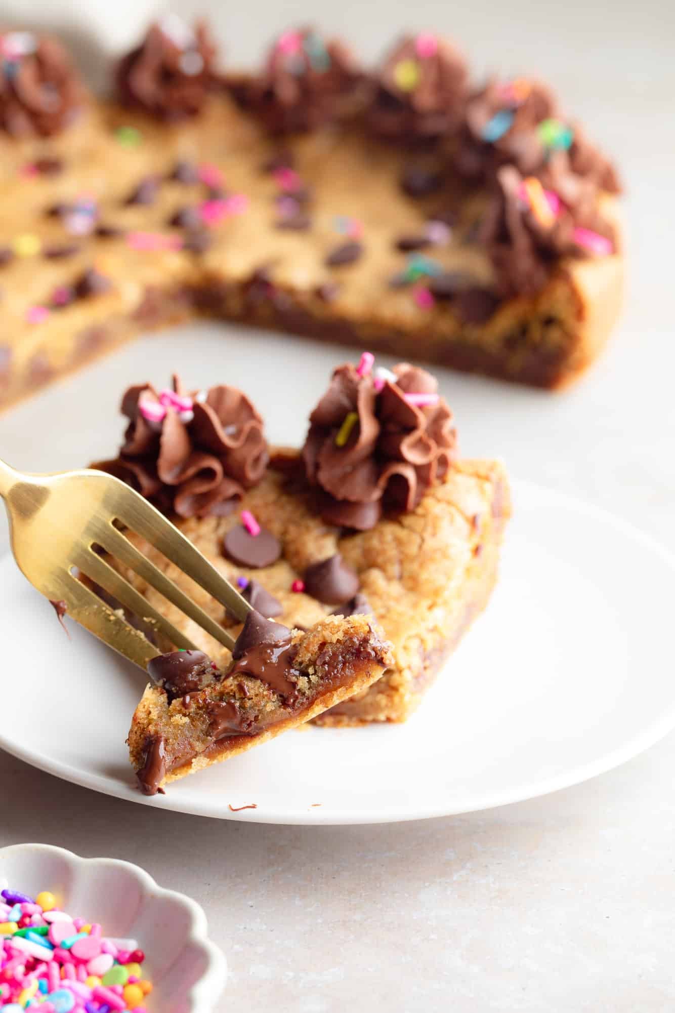 Near a fork holding a bite of a vegan cookie cake.