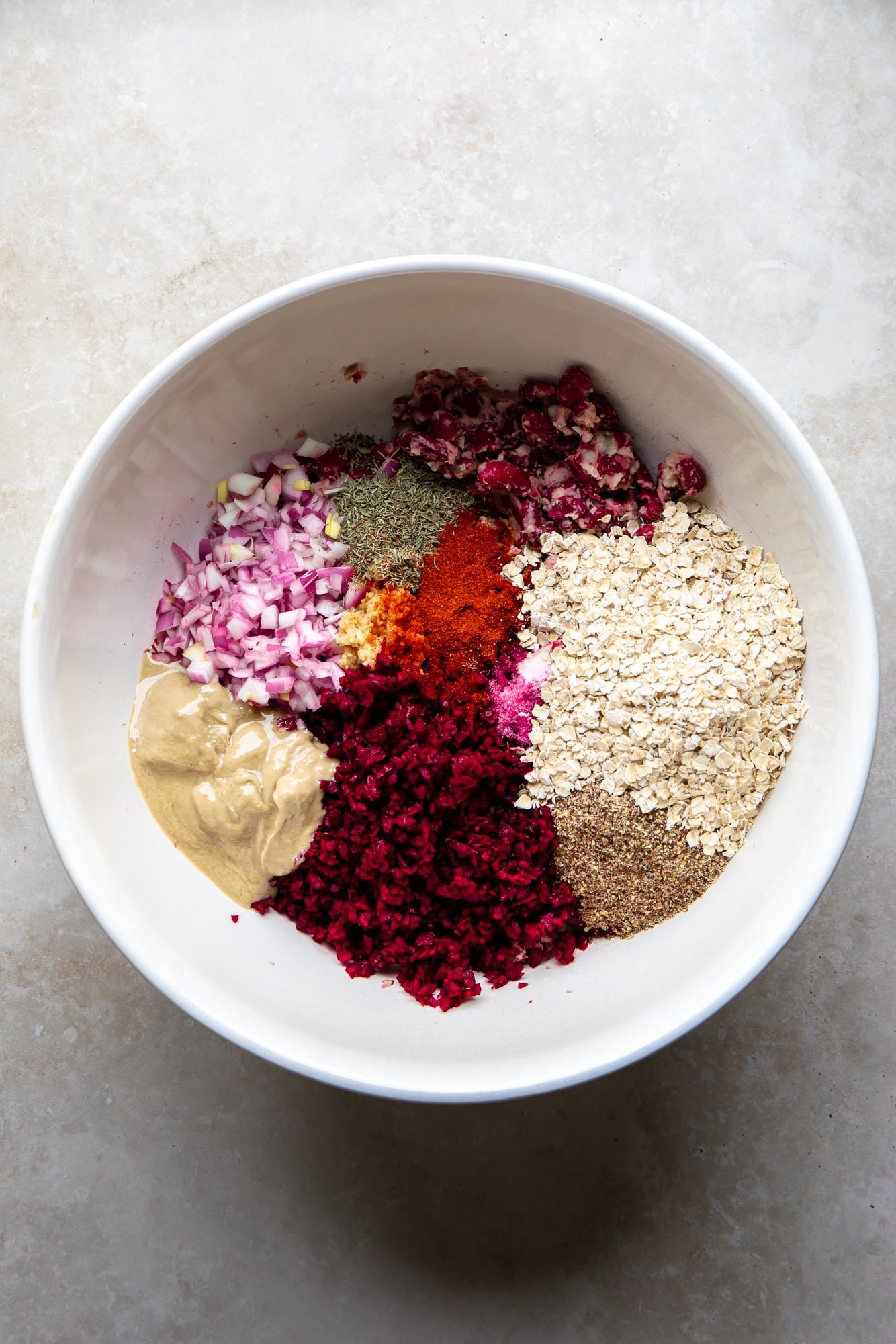 The ingredients for the boot beet burgers together in a white bowl.
