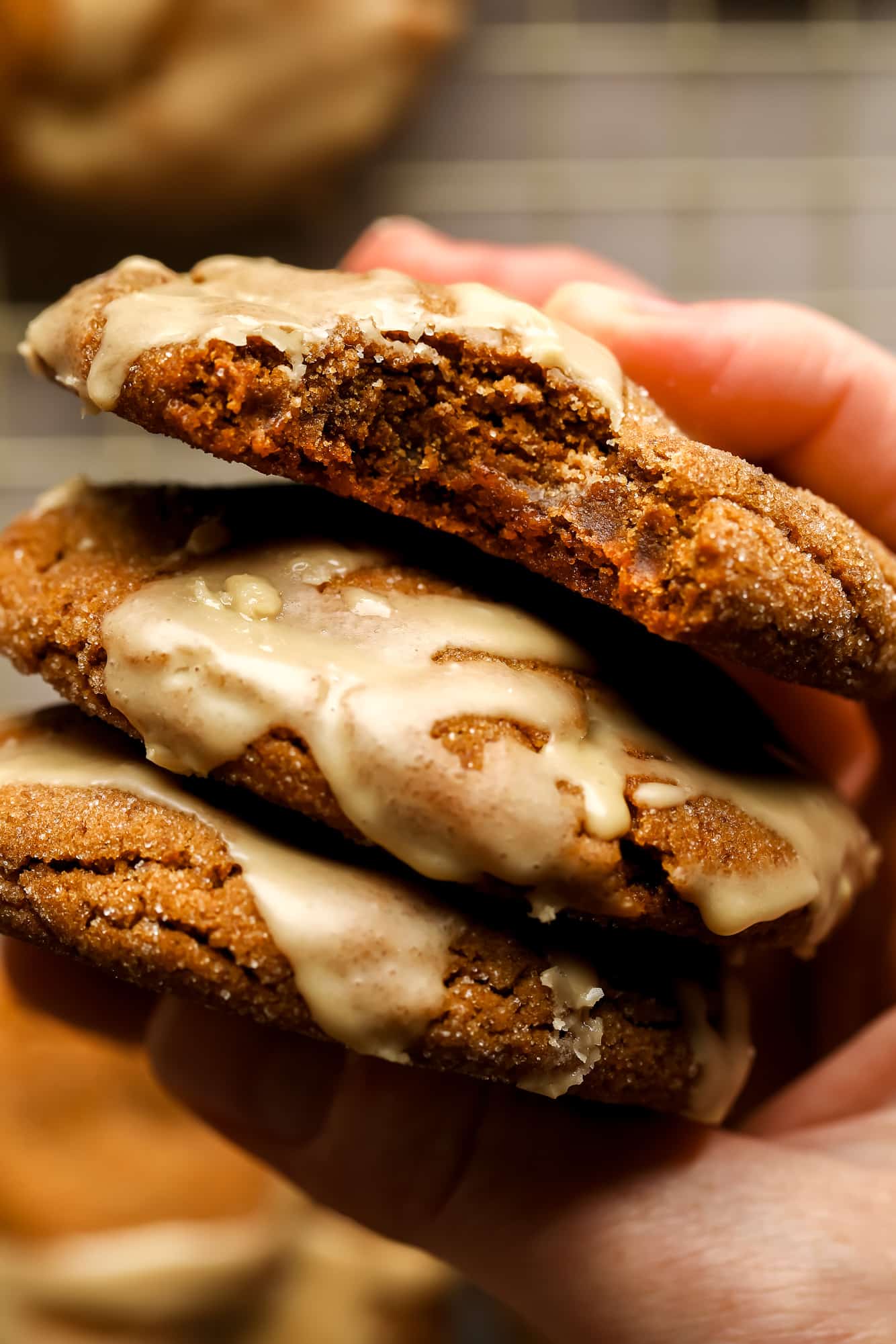 A hand of Womans holding a pile of ginger ice cookies.