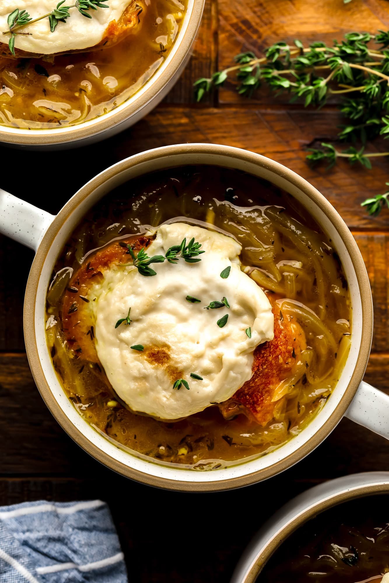 A bowl of vegan French onion soup finished off with toasted vegan cheese bread.