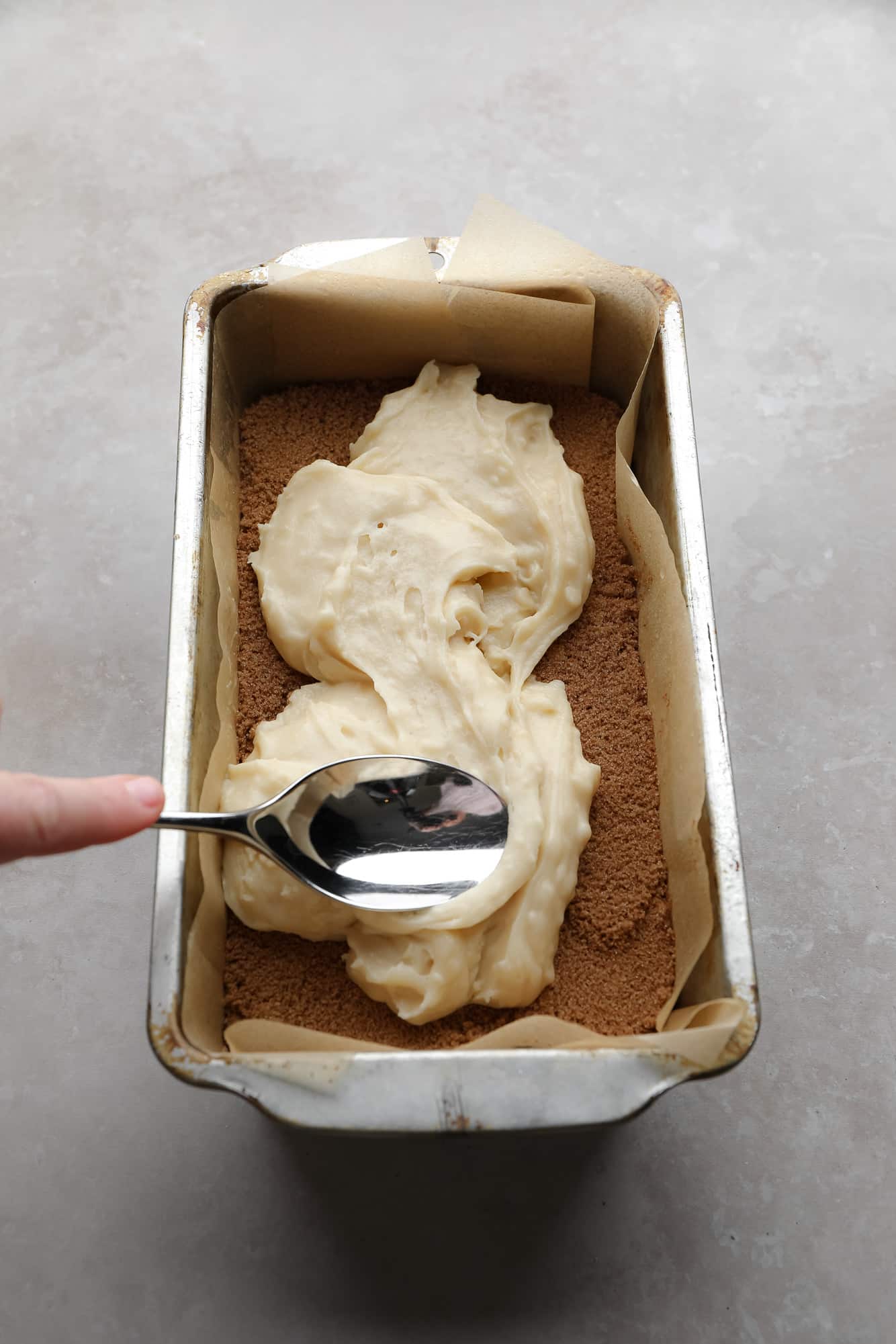 Use a spoon to spread the bread whisk on a layer of cinnamon sugar in a pan.