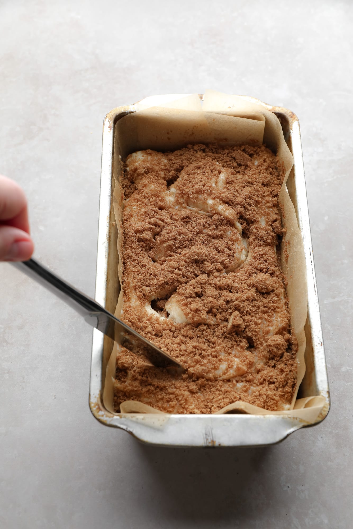 Using a knife to make a whirlwind pattern in bread whisk in a pan.