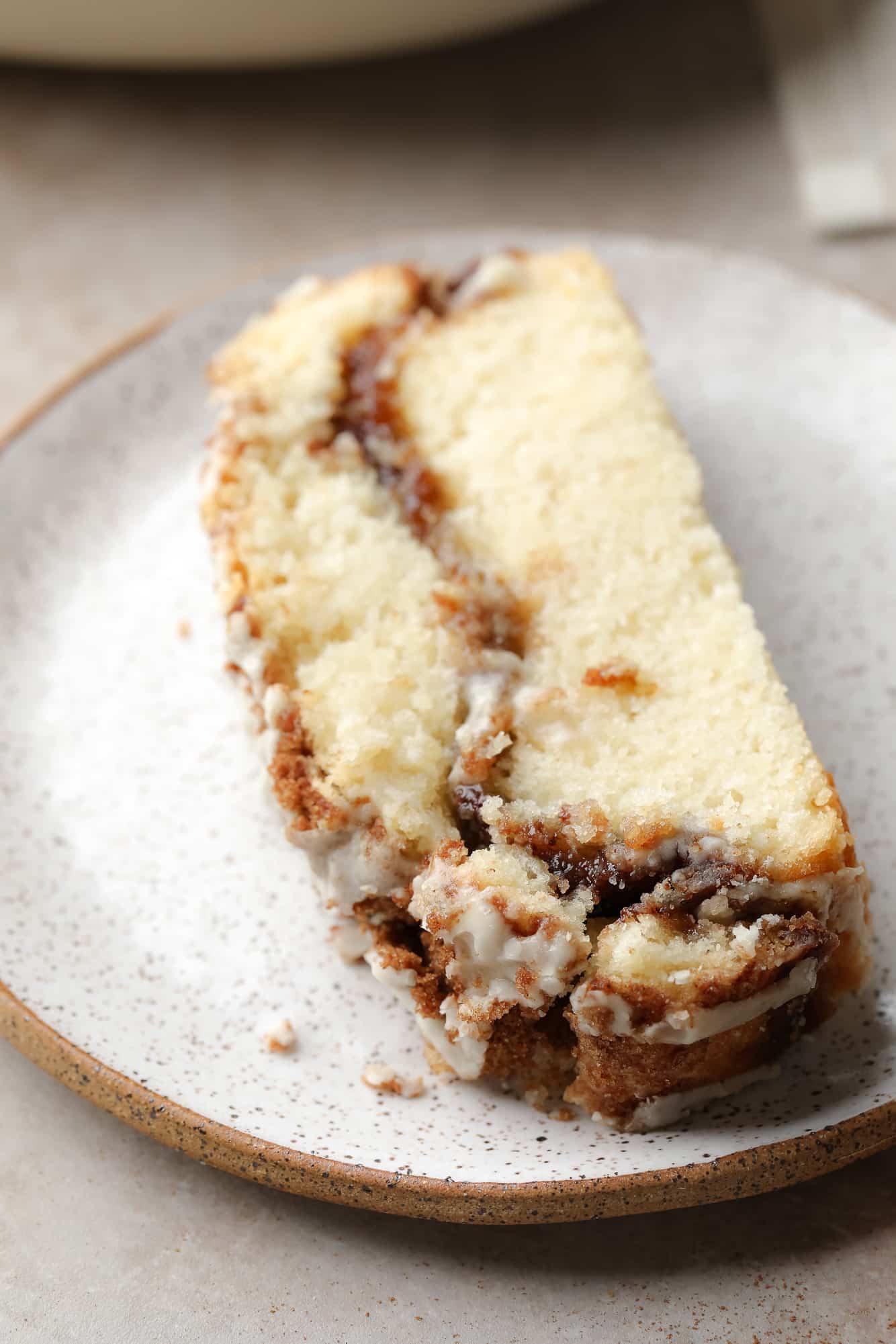 A slice of vegan cinnamon bread whirlwind fast bread on a white dish.