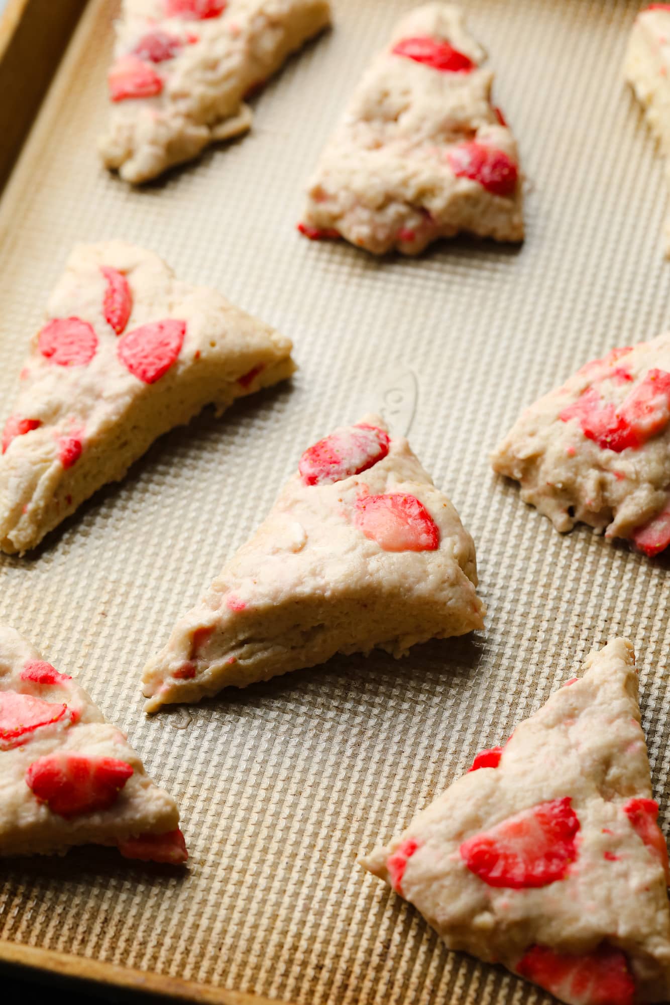 Vegan strawberry scones unmistakably on a cooking leaf.