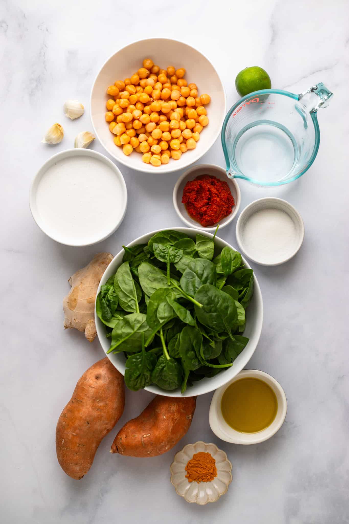 Ingredients for sweet potato curry with chickpeas in individual white bowls.