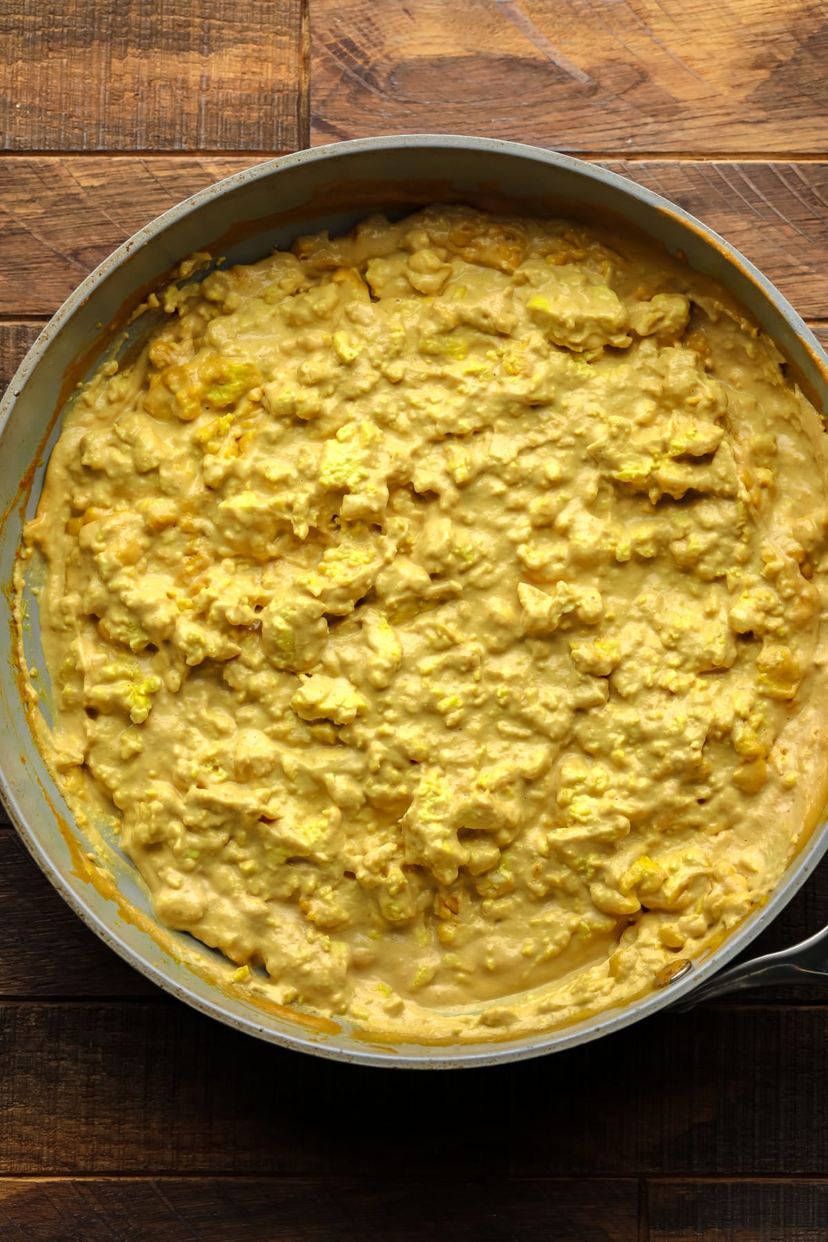 The yellow mixture that seeks eggs in the pan of the wooden board
