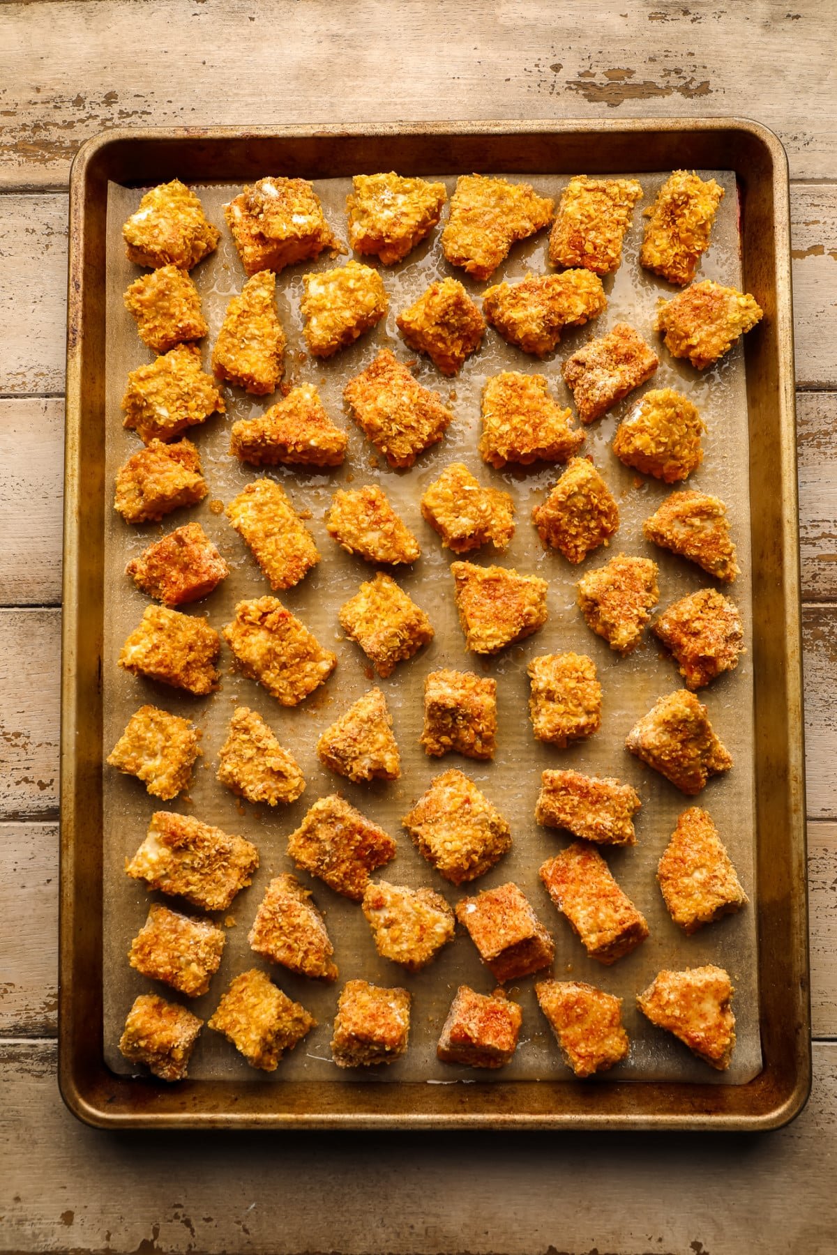 pieces of crunchy tofu on a gold pan on a wooden background