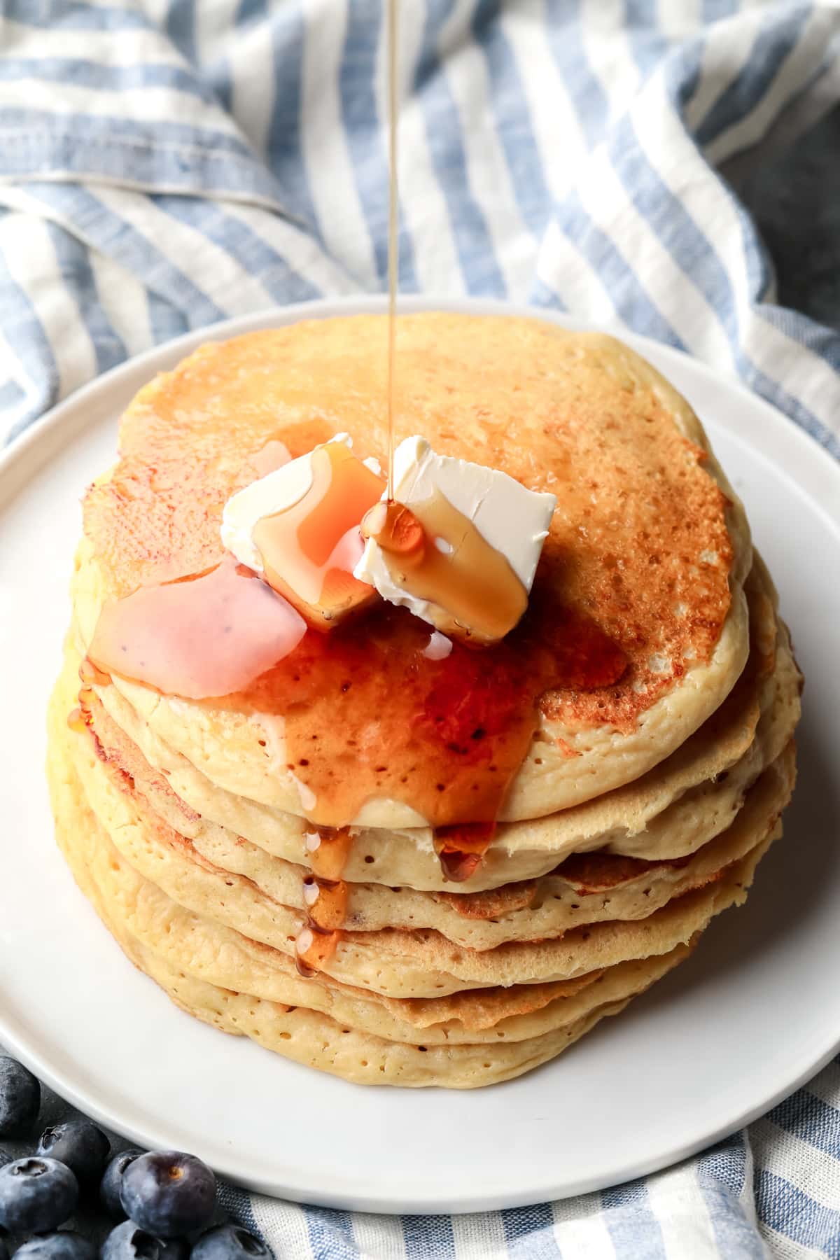 Arce sirope that adjusts to the top of a pile of vegan protein pancakes.