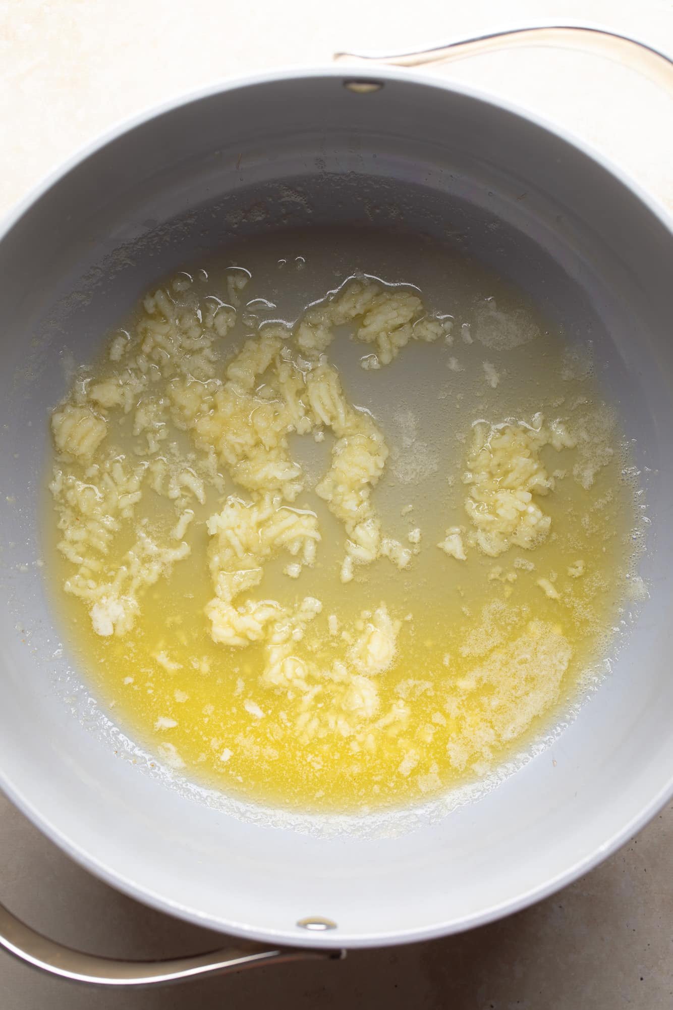 Sauté the garlic in melted butter in a gray pan.